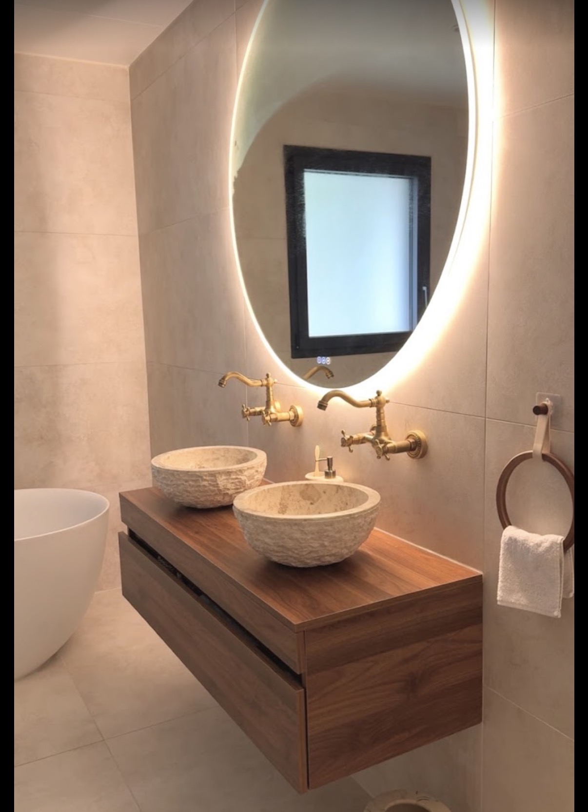 Double vasque en pierre sur meuble bois avec miroir lumineux doré