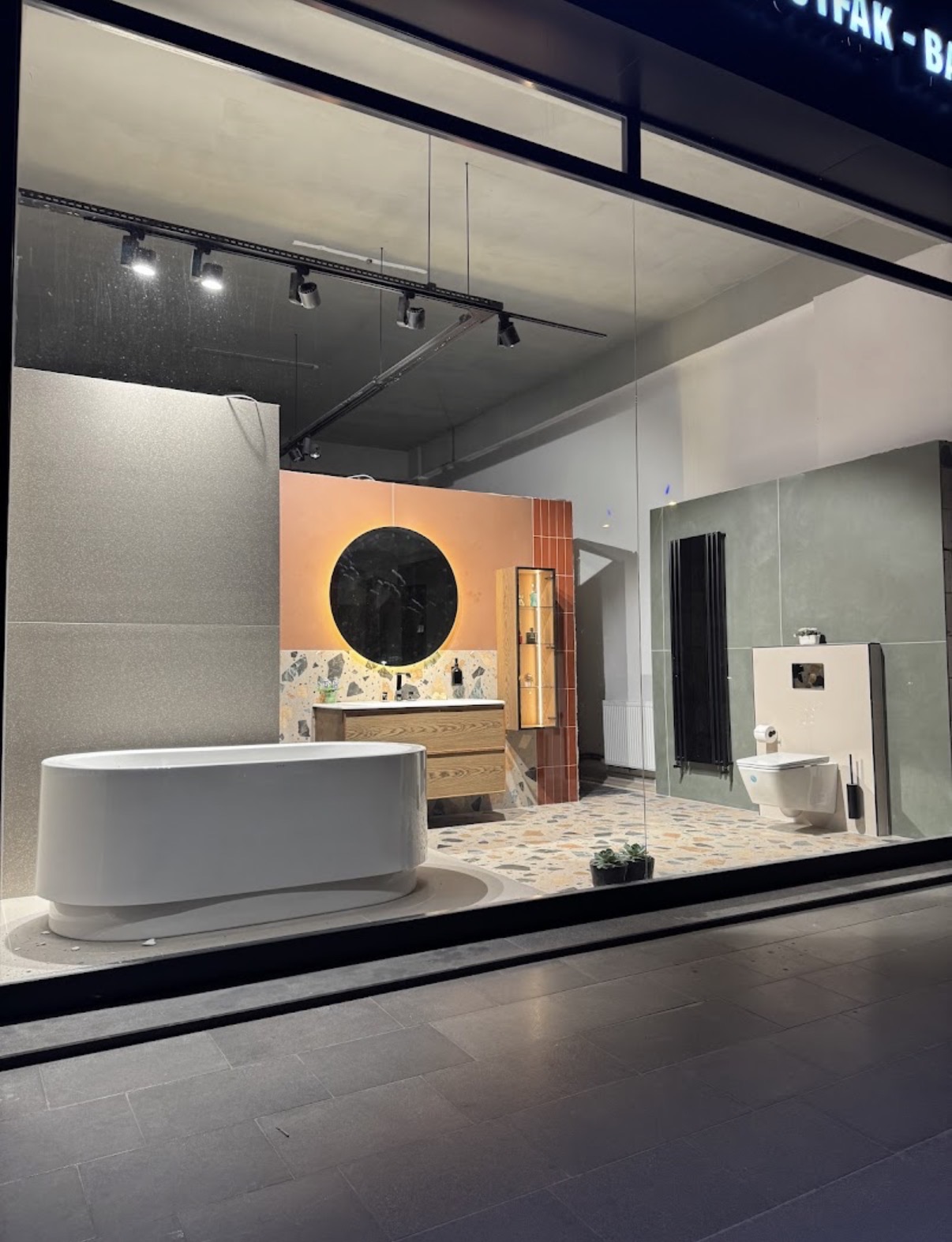 Vitrine de showroom présentant une salle de bain avec baignoire îlot